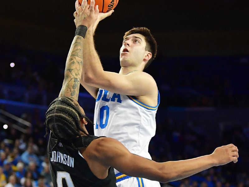 January 14, 2024; Los Angeles, California, USA; UCLA Bruins guard Lazar Stefanovic (10) moves to the basket against Washington Huskies guard Koren Johnson (0) during the second half at Pauley Pavilion. Mandatory Credit: Gary A. Vasquez-USA TODAY Sports