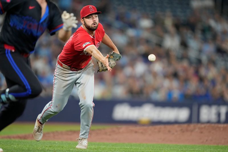 Aug 23, 2024; Toronto, Ontario, CAN; Los Angeles Angels first baseman Nolan Schanuel (18) commits a throwing error on a ball hit by Toronto Blue Jays first baseman Spencer Horwitz (48) during the sixth inning at Rogers Centre. Mandatory Credit: John E. Sokolowski-USA TODAY Sports