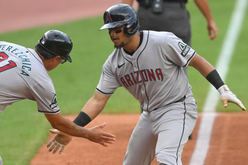 Aug 5, 2024; Cleveland, Ohio, USA; Arizona Diamondbacks catcher Gabriel Moreno (14) celebrates his solo home run with third base coach Tony Perezchica (21) in the first inning against the Cleveland Guardians at Progressive Field. Mandatory Credit: David Richard-USA TODAY Sports