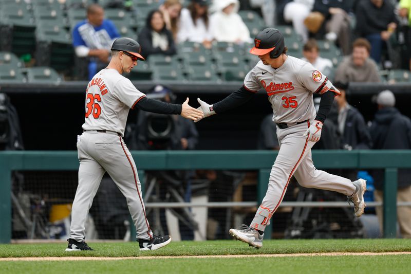 May 26, 2024; Chicago, Illinois, USA; Baltimore Orioles catcher Adley Rutschman (35) is congratulated by third base coach Tony Mansolino (36) as he rounds the bases after hitting a two-run home run against the Chicago White Sox during the sixth inning at Guaranteed Rate Field. Mandatory Credit: Kamil Krzaczynski-USA TODAY Sports