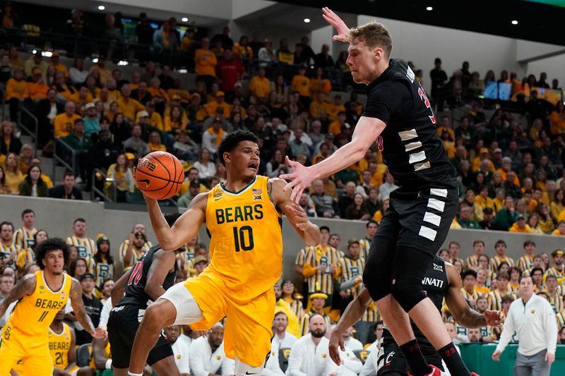 Jan 13, 2024; Waco, Texas, USA; Baylor Bears guard RayJ Dennis (10) passes the ball past Cincinnati Bearcats forward Viktor Lakhin (30) during the second half at Paul and Alejandra Foster Pavilion. Mandatory Credit: Raymond Carlin III-USA TODAY Sports