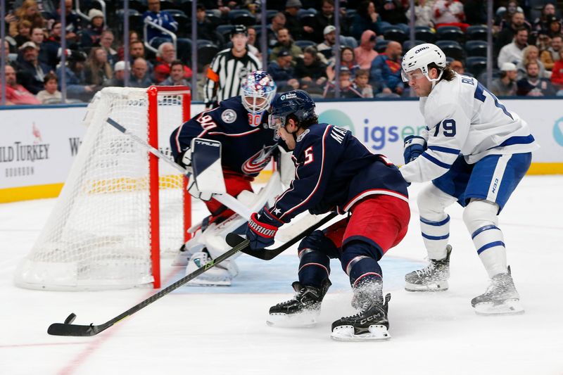 Oct 29, 2025; Columbus, Ohio, USA; Columbus Blue Jackets defenseman Denton Mateychuk (5) picks up a rebound as Toronto Maple Leafs left wing Sammy Blais (79) trails the play during the third period at Nationwide Arena. Mandatory Credit: Russell LaBounty-Imagn Images