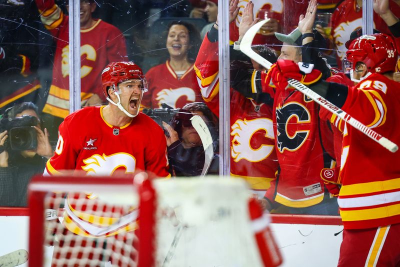 Nov 1, 2024; Calgary, Alberta, CAN; Calgary Flames center Jonathan Huberdeau (10) celebrates his goal with teammates against the New Jersey Devils during the third period at Scotiabank Saddledome. Mandatory Credit: Sergei Belski-Imagn Images