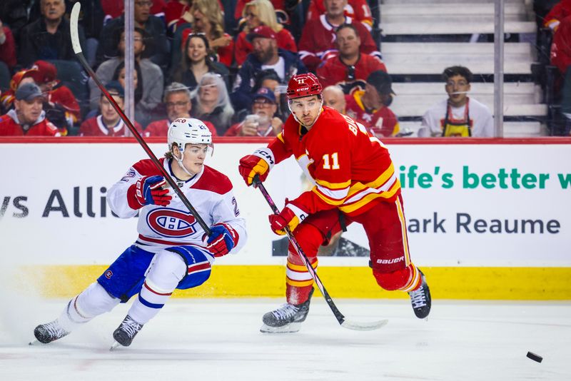 Mar 16, 2024; Calgary, Alberta, CAN; Montreal Canadiens right wing Cole Caufield (22) and Calgary Flames center Mikael Backlund (11) battles for the puck during the first period at Scotiabank Saddledome. Mandatory Credit: Sergei Belski-USA TODAY Sports