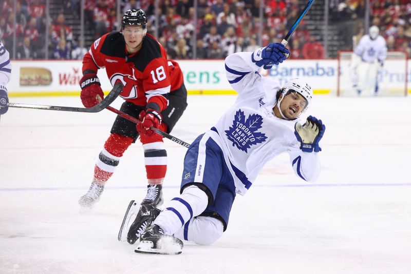 Oct 10, 2024; Newark, New Jersey, USA; Toronto Maple Leafs left wing Nicholas Robertson (89) is pulled down by New Jersey Devils left wing Ondrej Palat (18) during the third period at Prudential Center. Mandatory Credit: Ed Mulholland-Imagn Images