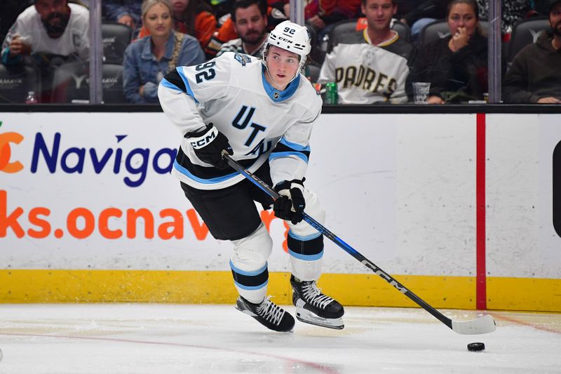 Oct 16, 2024; Anaheim, California, USA; Utah Hockey Club center Logan Cooley (92) moves the puck against the Anaheim Ducks during the third period at Honda Center. Mandatory Credit: Gary A. Vasquez-Imagn Images