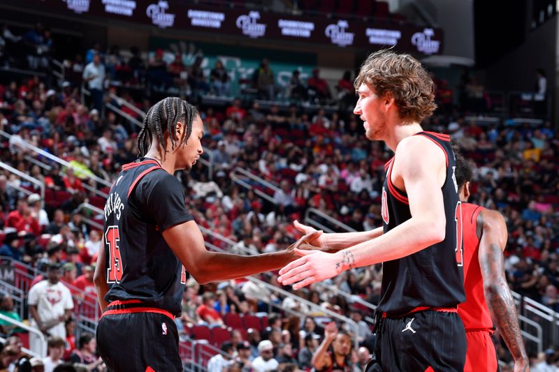 HOUSTON, TX - MARCH 15: Julian Phillips #15 and Matas Buzelis #14 of Chicago Bulls high five during the game against the Houston Rockets on March 15, 2025 at the Toyota Center in Houston, Texas. NOTE TO USER: User expressly acknowledges and agrees that, by downloading and or using this photograph, User is consenting to the terms and conditions of the Getty Images License Agreement. Mandatory Copyright Notice: Copyright 2025 NBAE (Photo by Logan Riely/NBAE via Getty Images)