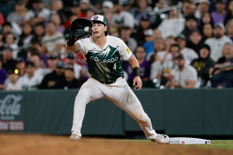 Aug 10, 2024; Denver, Colorado, USA; Colorado Rockies first baseman Michael Toglia (4) fields a throw in the seventh inning against the Atlanta Braves at Coors Field. Mandatory Credit: Isaiah J. Downing-USA TODAY Sports