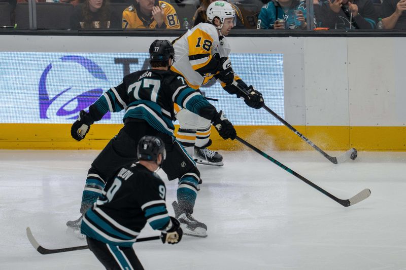 Oct 18, 2025; San Jose, California, USA; Pittsburgh Penguins center Tommy Novak (18) passes the puck defended by San Jose Sharks center Michael Misa (77) during the third period at SAP Center at San Jose. Mandatory Credit: Neville E. Guard-Imagn Images