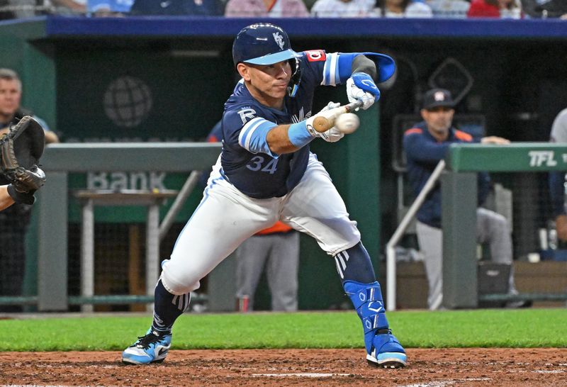 Apr 25, 2025; Kansas City, Missouri, USA;  Kansas City Royals catcher Freddy Fermin (34) puts down a sacrifice bunt in the fifth inning against the Houston Astros at Kauffman Stadium. Mandatory Credit: Peter Aiken-Imagn Images
