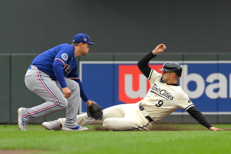 May 26, 2024; Minneapolis, Minnesota, USA;  Texas Rangers outfielder Corey Seager (5) tags out Minnesota Twins designated hitter Trevor Larnach (9) to complete a double play during the first inning at Target Field. Mandatory Credit: Nick Wosika-USA TODAY Sports