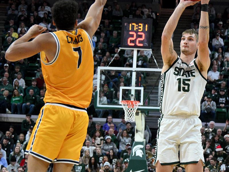 Dec 16, 2025; East Lansing, Michigan, USA; Michigan State Spartans center Carson Cooper (15) shoots over the defense of Toledo Rockets forward Sean Craig (7) during the second half at Jack Breslin Student Events Center. Mandatory Credit: Dale Young-Imagn Images