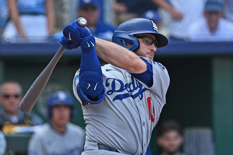 Jun 28, 2025; Kansas City, Missouri, USA;  Los Angeles Dodgers third baseman Max Muncy (13) hits an RBI single in the ninth inning against the Kansas City Royals at Kauffman Stadium. Mandatory Credit: Peter Aiken-Imagn Images