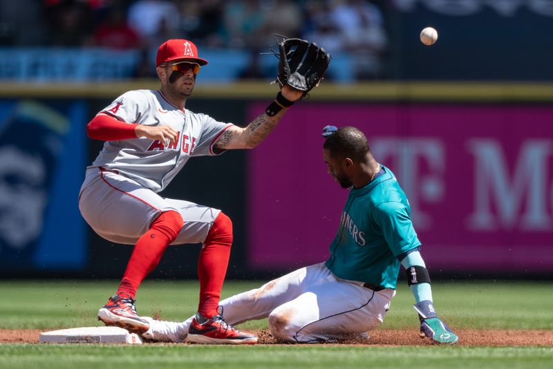 Jul 24, 2024; Seattle, Washington, USA;  Seattle Mariners centerfielder Victor Robles (10) steals second base ahead of a tag by Los Angeles Angels shortstop Zach Neto (9) during the first inning at T-Mobile Park. Mandatory Credit: Stephen Brashear-USA TODAY Sports