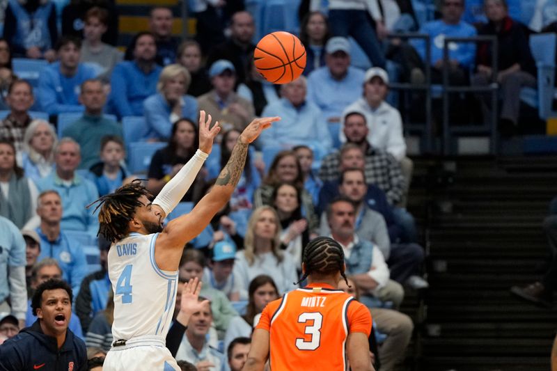 Jan 13, 2024; Chapel Hill, North Carolina, USA; North Carolina Tar Heels guard RJ Davis (4) shoots as Syracuse Orange guard Judah Mintz (3) defends in the first half at Dean E. Smith Center. Mandatory Credit: Bob Donnan-USA TODAY Sports