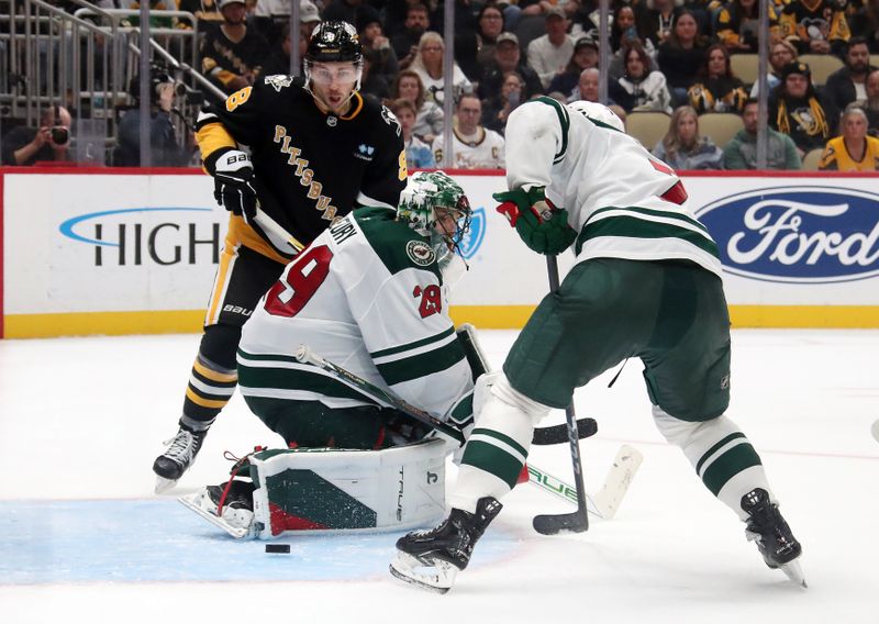 Oct 29, 2024; Pittsburgh, Pennsylvania, USA;  Minnesota Wild goaltender Marc-Andre Fleury (29) makes a save as Pittsburgh Penguins left wing Michael Bunting (8) looks for a rebound and Wild defenseman Brock Faber (7) defends during the third period at PPG Paints Arena. Mandatory Credit: Charles LeClaire-Imagn Images
