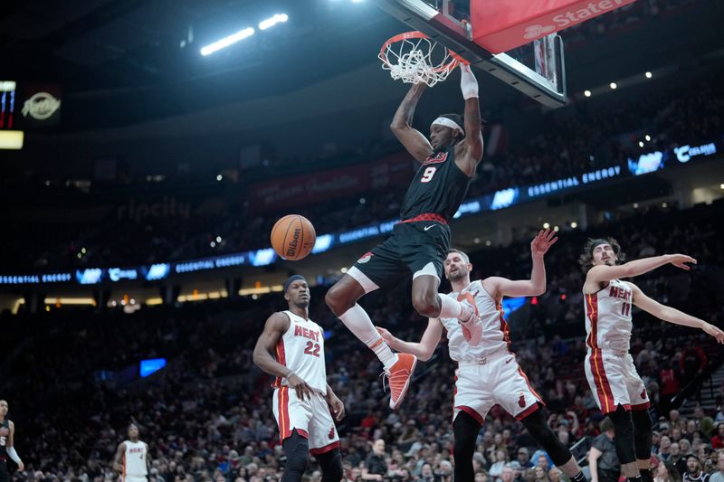 PORTLAND, OREGON - FEBRUARY 27: Jerami Grant #9 of the Portland Trail Blazers dunks the ball over Kevin Love #42 (R) of the Miami Heat during the first half at Moda Center on February 27, 2024 in Portland, Oregon. NOTE TO USER: User expressly acknowledges and agrees that, by downloading and or using this photograph, User is consenting to the terms and conditions of the Getty Images License Agreement. (Photo by Soobum Im/Getty Images)