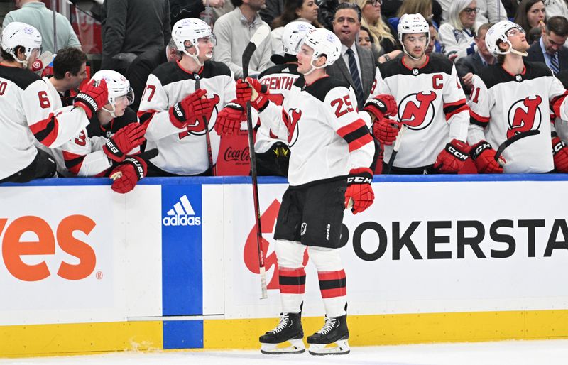 Apr 11, 2024; Toronto, Ontario, CAN; New Jersey Devils forward Nolan Foote (25) celebrates with team mates at the bench after scoring a goal against the Toronto Maple Leafs in the first period at Scotiabank Arena. Mandatory Credit: Dan Hamilton-USA TODAY Sports