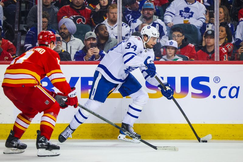 Jan 18, 2024; Calgary, Alberta, CAN; Toronto Maple Leafs center Auston Matthews (34) passes the puck against the Calgary Flames during the third period at Scotiabank Saddledome. Mandatory Credit: Sergei Belski-USA TODAY Sports