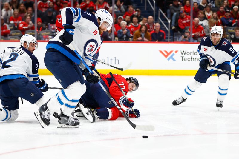 Mar 24, 2024; Washington, District of Columbia, USA; Winnipeg Jets center Adam Lowry (17) battles for the puck with Washington Capitals right wing T.J. Oshie (77) during the third period at Capital One Arena. Mandatory Credit: Amber Searls-USA TODAY Sports