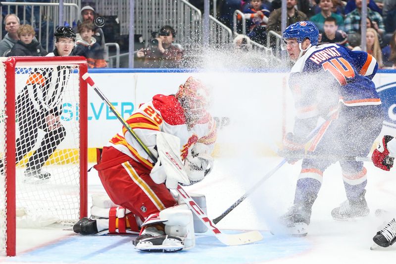 Feb 10, 2024; Elmont, New York, USA;  Calgary Flames goaltender Jacob Markstrom (25) makes a save on a shot on goal attempt by New York Islanders center Bo Horvat (14) in the second period at UBS Arena. Mandatory Credit: Wendell Cruz-USA TODAY Sports