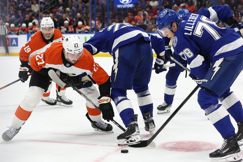 Nov 7, 2024; Tampa, Florida, USA; Philadelphia Flyers left wing Noah Cates (27) and Tampa Bay Lightning defenseman Emil Lilleberg (78) fight to control the puck during the second period at Amalie Arena. Mandatory Credit: Kim Klement Neitzel-Imagn Images