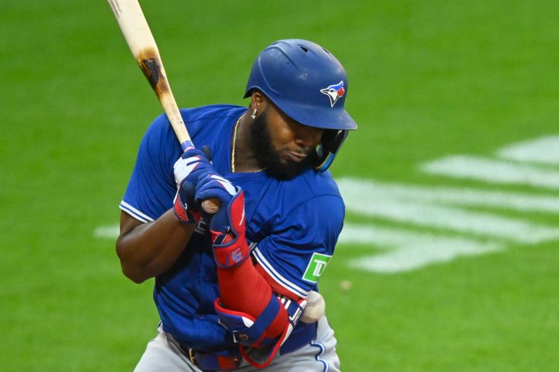 Jun 25, 2025; Cleveland, Ohio, USA; Toronto Blue Jays first baseman Vladimir Guerrero Jr. (27) is hit by a pitch in the eighth inning against the Cleveland Guardians at Progressive Field. Mandatory Credit: David Richard-Imagn Images