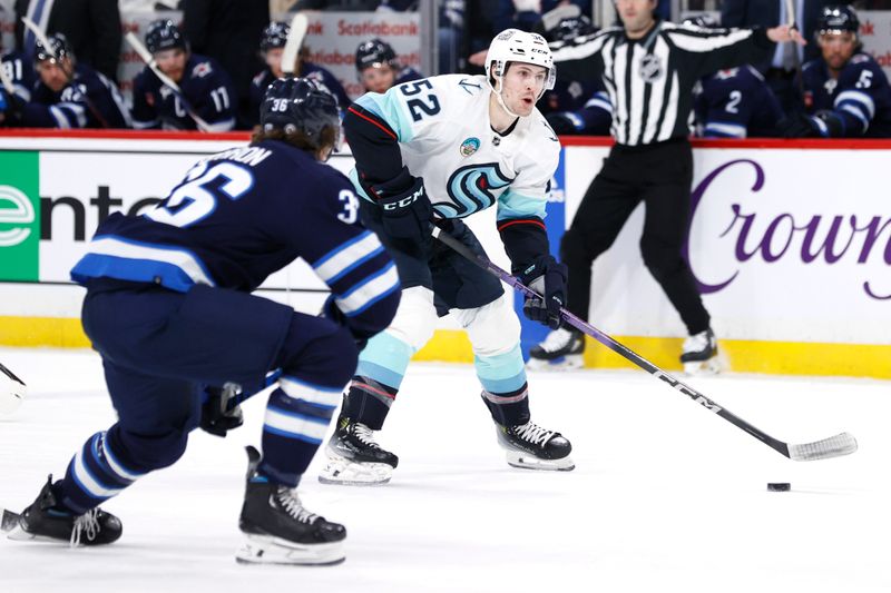 Mar 5, 2024; Winnipeg, Manitoba, CAN; Seattle Kraken left wing Tye Kartye (52) is chased down by Winnipeg Jets center Morgan Barron (36) in the first period at Canada Life Centre. Mandatory Credit: James Carey Lauder-USA TODAY Sports