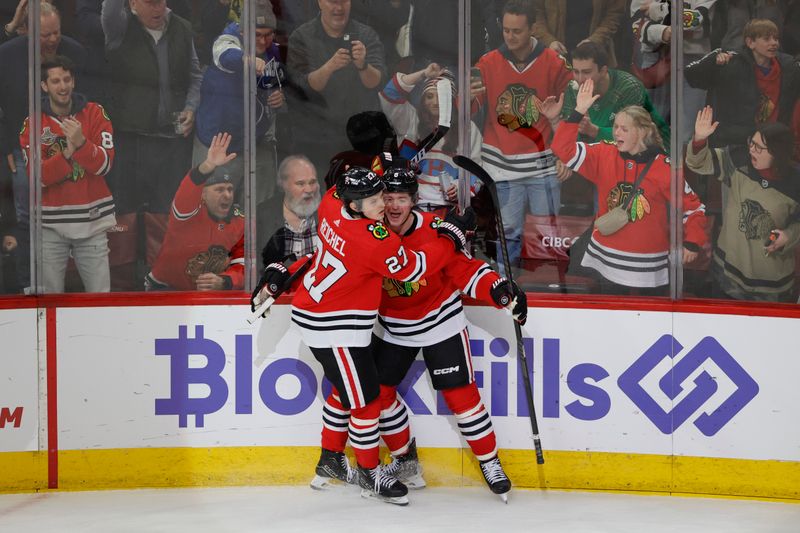 Dec 22, 2023; Chicago, Illinois, USA; Chicago Blackhawks center Ryan Donato (8) celebrates with left wing Lukas Reichel (27) after scoring against the Montreal Canadiens during the first period at United Center. Mandatory Credit: Kamil Krzaczynski-USA TODAY Sports