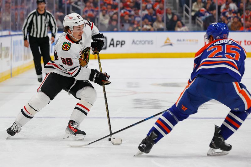 Nov 1, 2025; Edmonton, Alberta, CAN; Edmonton Oilers defensemen Darnell Nurse (25) knocks the puck away from Chicago Blackhawks forward Connor Bedard (98) during the second period at Rogers Place. Mandatory Credit: Perry Nelson-Imagn Images