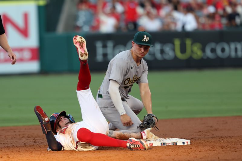 Jul 25, 2024; Anaheim, California, USA;  Los Angeles Angels shortstop Zach Neto (9) is safe at the second ahead of a tag from Oakland Athletics second baseman Zack Gelof (20)during the second inning at Angel Stadium. Mandatory Credit: Kiyoshi Mio-USA TODAY Sports