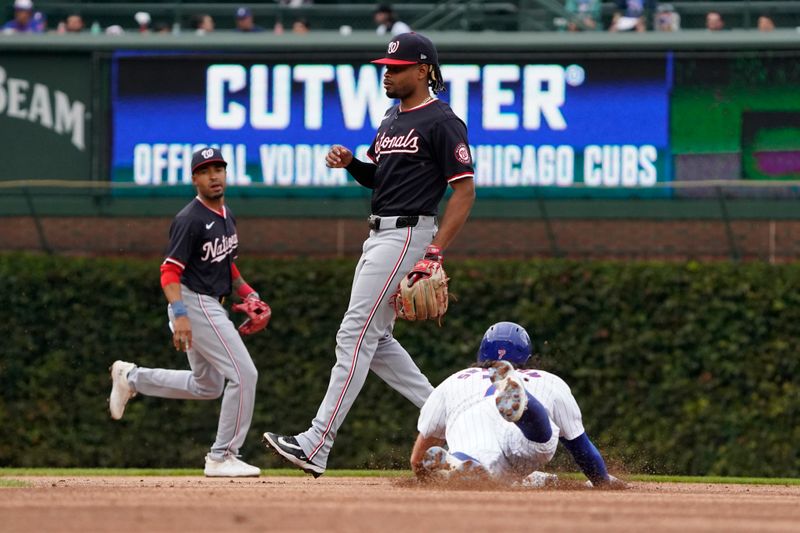 Sep 22, 2024; Chicago, Illinois, USA; Chicago Cubs shortstop Dansby Swanson (7) steals second base as Washington Nationals second baseman José Tena (8) stands nearby during the first inning at Wrigley Field. Mandatory Credit: David Banks-Imagn Images