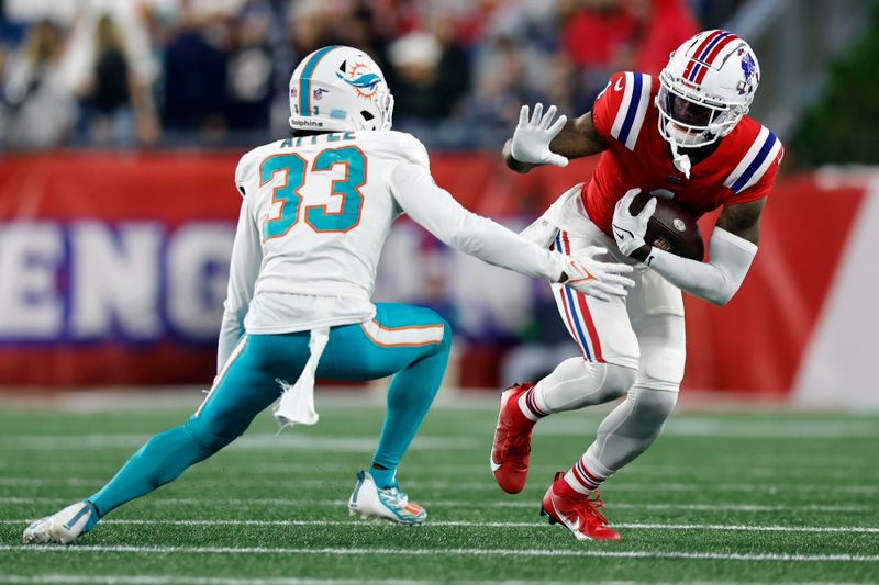 New England Patriots wide receiver DeVante Parker (1) carries the ball against Miami Dolphins cornerback Eli Apple (33) during an NFL football game, Sunday, Sept. 17, 2023, in Foxborough, Mass. (AP Photo/Michael Dwyer)