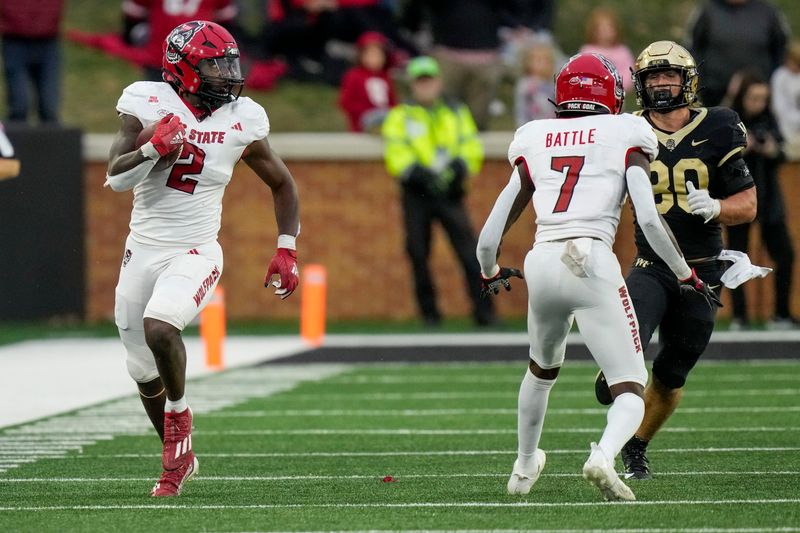 Nov 11, 2023; Winston-Salem, North Carolina, USA; North Carolina State Wolfpack linebacker Jaylon Scott (2) watches a block by cornerback Shyheim Battle (7) as he runs back an extra point interception against the Wake Forest Demon Deacons during the second half at Allegacy Federal Credit Union Stadium. Mandatory Credit: Jim Dedmon-USA TODAY Sports