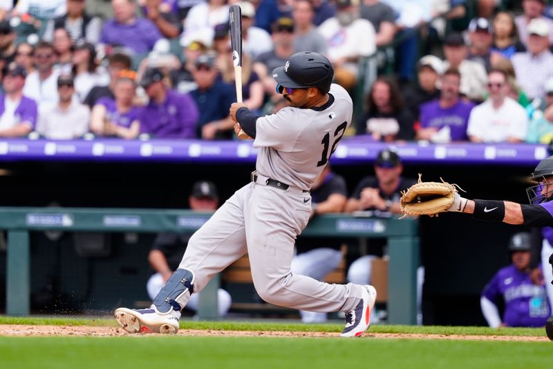 May 24, 2025; Denver, Colorado, USA; New York Yankees center fielder Trent Grisham (12) hits a two run double in the fifth inning against the Colorado Rockies at Coors Field. Mandatory Credit: Ron Chenoy-Imagn Images