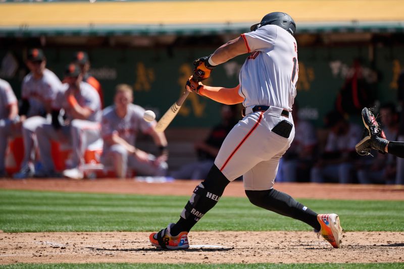 Aug 18, 2024; Oakland, California, USA; San Francisco Giants outfielder Heliot Ramos (17) hits a one run home run against the Oakland Athletics during the seventh inning at Oakland-Alameda County Coliseum. Mandatory Credit: Robert Edwards-USA TODAY Sports