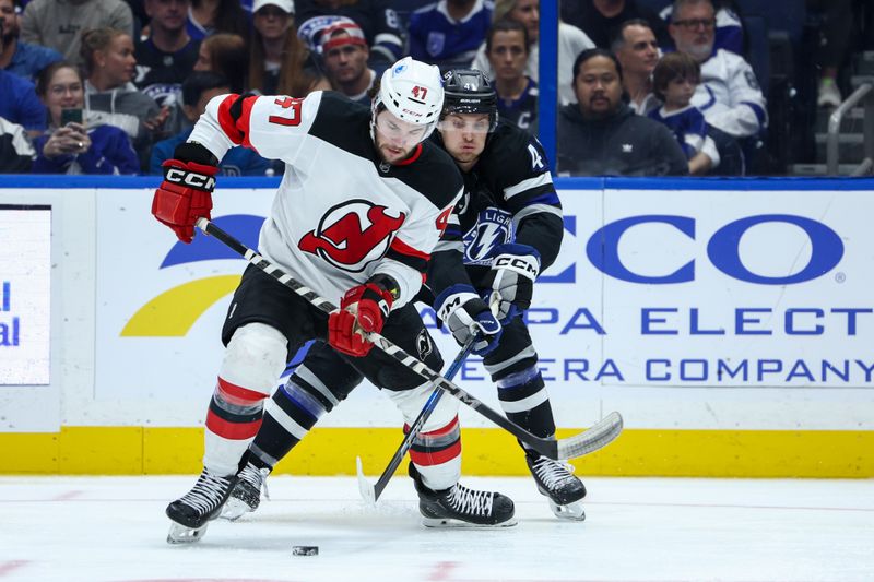 Nov 16, 2024; Tampa, Florida, USA; New Jersey Devils center Paul Cotter (47) controls the puck from Tampa Bay Lightning right wing Mitchell Chaffee (41) in the second period at Amalie Arena. Mandatory Credit: Nathan Ray Seebeck-Imagn Images