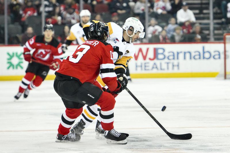 Apr 2, 2024; Newark, New Jersey, USA; Pittsburgh Penguins center Sidney Crosby (87) skates with the puck while being defended by New Jersey Devils center Nico Hischier (13) during the first period at Prudential Center. Mandatory Credit: John Jones-USA TODAY Sports