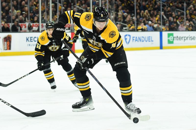 Jan 30, 2025; Boston, Massachusetts, USA;  Boston Bruins center Trent Frederic (11) tries to gain control of the puck during the first period against the Winnipeg Jets at TD Garden. Mandatory Credit: Bob DeChiara-Imagn Images