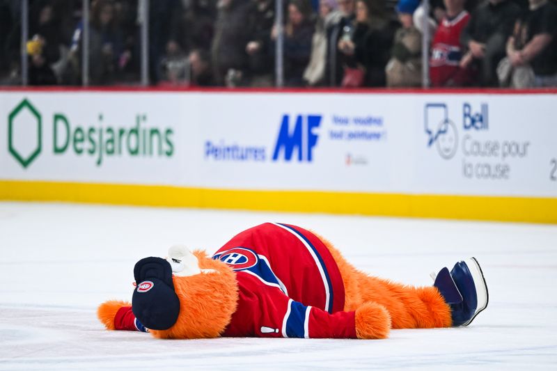 Jan 21, 2025; Montreal, Quebec, CAN; Montreal Canadiens mascot Youppi lays on the ice after the win against the Tampa Bay Lightning at Bell Centre. Mandatory Credit: David Kirouac-Imagn Images