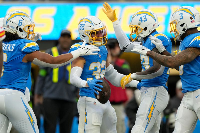 Los Angeles Chargers safety Alohi Gilman, center, celebrates with teammates after an interception during the first half of an NFL football game against the Kansas City Chiefs, Sunday, Jan. 7, 2024, in Inglewood, Calif. (AP Photo/Ashley Landis)