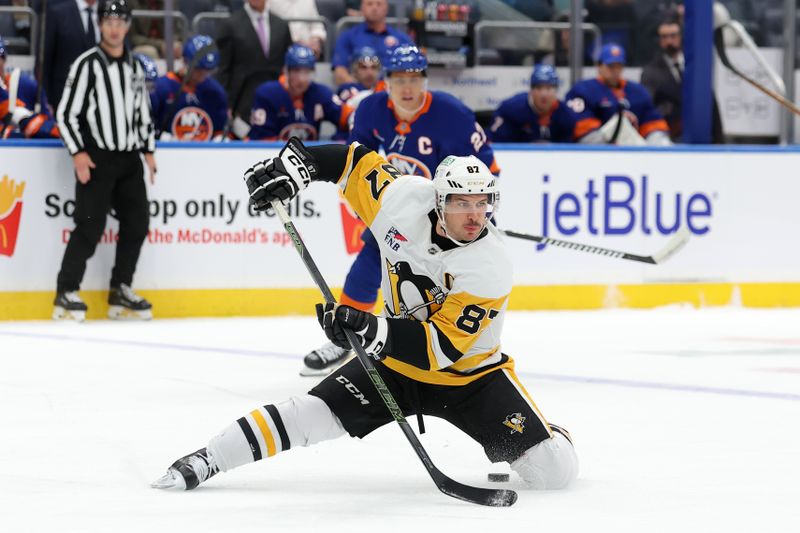 Nov 5, 2024; Elmont, New York, USA; Pittsburgh Penguins center Sidney Crosby (87) passes the puck backwards between his legs during the first period against the New York Islanders at UBS Arena. Mandatory Credit: Brad Penner-Imagn Images