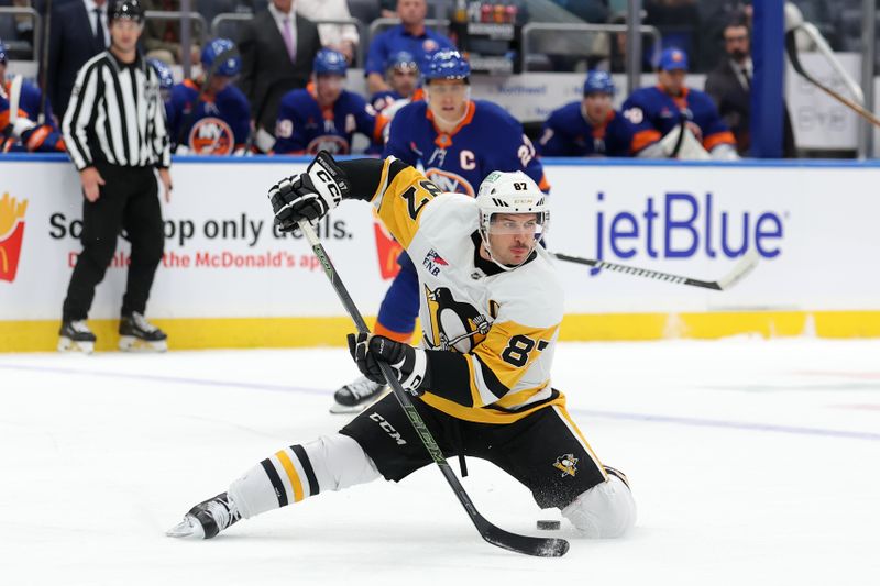 Nov 5, 2024; Elmont, New York, USA; Pittsburgh Penguins center Sidney Crosby (87) passes the puck backwards between his legs during the first period against the New York Islanders at UBS Arena. Mandatory Credit: Brad Penner-Imagn Images