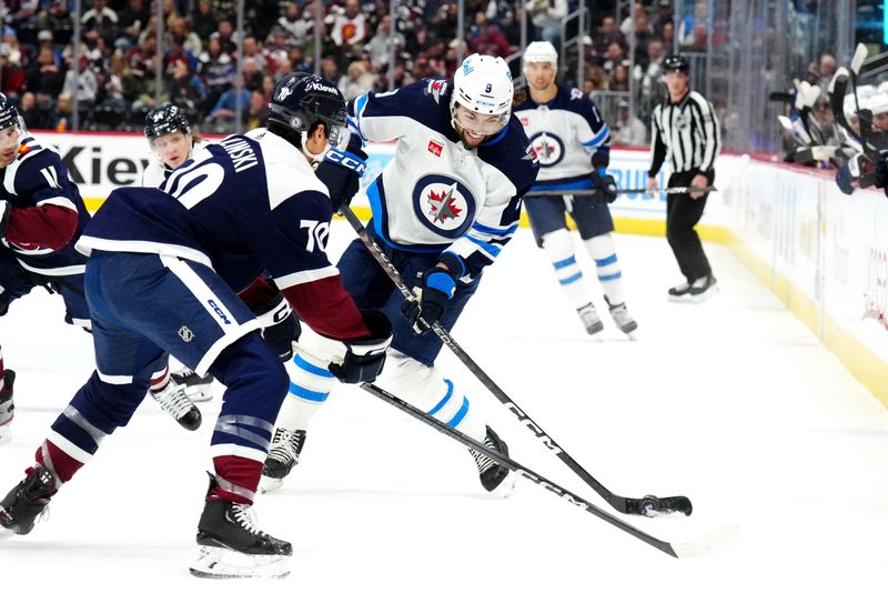 Dec 7, 2023; Denver, Colorado, USA; Winnipeg Jets left wing Alex Iafallo (9) shoots the puck towards Colorado Avalanche defenseman Sam Malinski (70) in the first period at Ball Arena. Mandatory Credit: Ron Chenoy-USA TODAY Sports