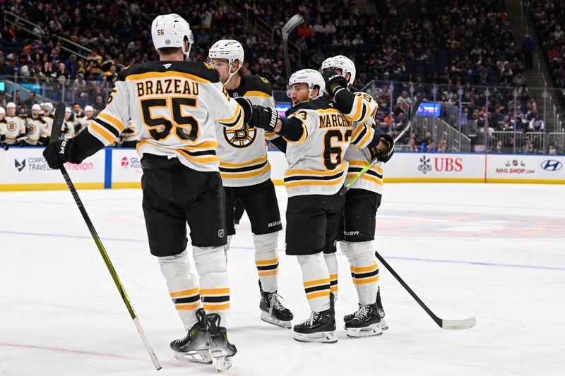 Nov 27, 2024; Elmont, New York, USA;  Boston Bruins left wing Brad Marchand (63) celebrates his second goal against the New York Islanders with Boston Bruins right wing Justin Brazeau (55) during the first period at UBS Arena. Mandatory Credit: Dennis Schneidler-Imagn Images