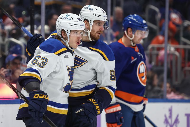 Nov 23, 2024; Elmont, New York, USA;  St. Louis Blues left wing Jake Neighbours (63) celebrates with left wing Pavel Buchnevich (89) after scoring a goal in the third period against the New York Islanders at UBS Arena. Mandatory Credit: Wendell Cruz-Imagn Images