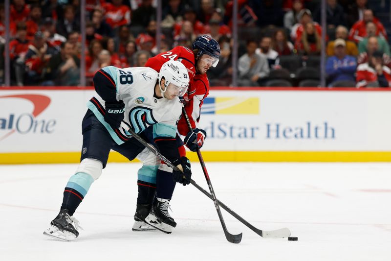 Oct 21, 2025; Washington, District of Columbia, USA; Washington Capitals center Connor McMichael (24) and Seattle Kraken defenseman Joshua Mahura (28) battle for the puck during the third period at Capital One Arena. Mandatory Credit: Geoff Burke-Imagn Images