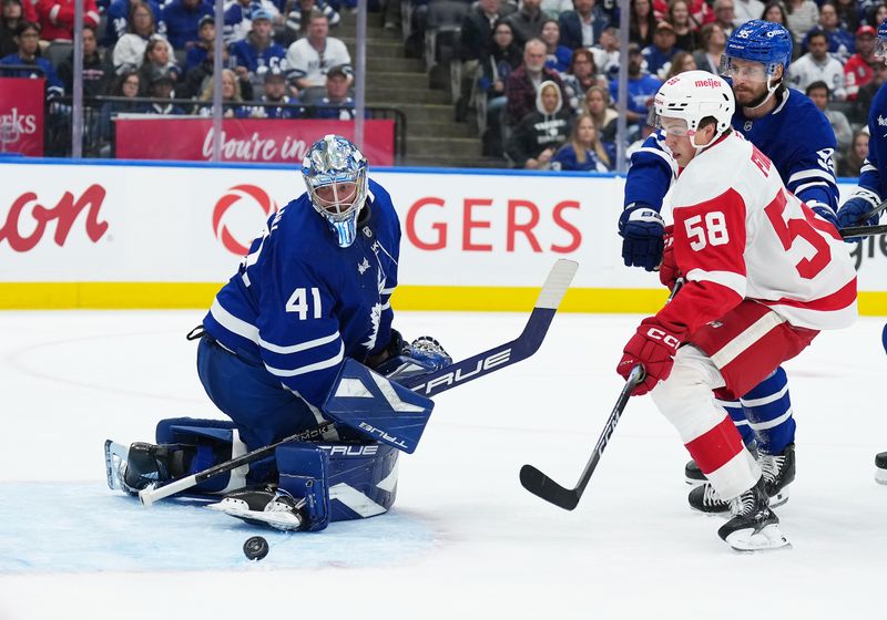 Oct 2, 2025; Toronto, Ontario, CAN; Detroit Red Wings center Emmitt Finnie (58) battles for the round in front of Toronto Maple Leafs goaltender Anthony Stolarz (41) during the second period at Scotiabank Arena. Mandatory Credit: Nick Turchiaro-Imagn Images