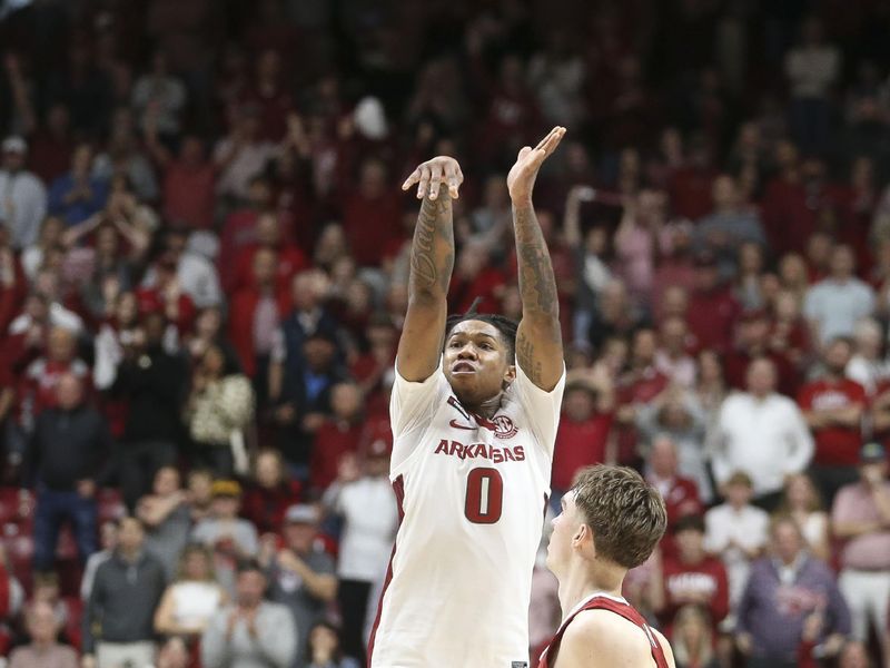 Mar 9, 2024; Tuscaloosa, Alabama, USA;  Arkansas guard Khalif Battle (0) takes a three over Alabama forward Grant Nelson (2) at Coleman Coliseum. Alabama came from behind to win on overtime 92-88. Mandatory Credit: Gary Cosby Jr.-USA TODAY Sports