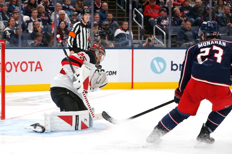 Oct 13, 2025; Columbus, Ohio, USA; New Jersey Devils goalie Jacob Markstrom (25) makes a save as Columbus Blue Jackets center Sean Monahan (23) looks for a rebound during the third period at Nationwide Arena. Mandatory Credit: Russell LaBounty-Imagn Images